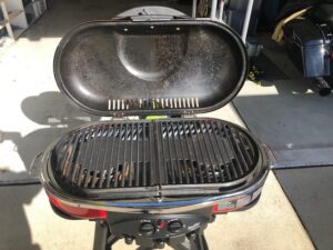 A grill that is sitting on the ground.