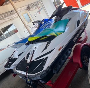 Two Seadoo GTI 130 & Yamaha VX 110 Sport jet skis parked in a garage.