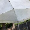 A white tent with black poles and tarps