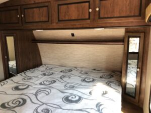 A bed with a mattress and a cabinet in it.