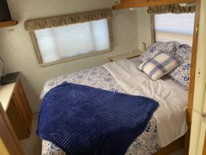 A 2000 Itasca Spirit 31' with a bed and a tv.