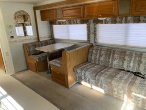 A 2000 Itasca Spirit 31' with a couch and a table.