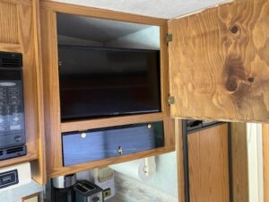 A tv is shown in the back of a cabinet.