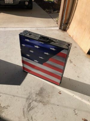 A suitcase with an american flag painted on it.