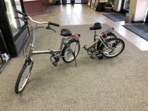 Two bikes parked on the floor of a building.