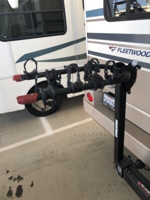 A bike rack in front of a recreational vehicle.