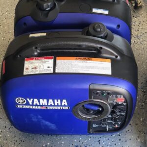 Two yamaha generators are sitting on the floor.