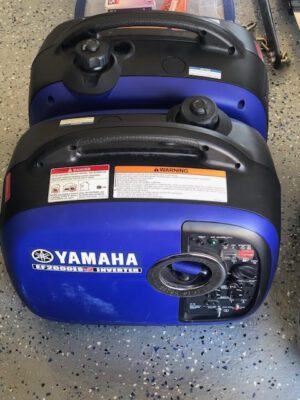 Two yamaha generators are sitting on the floor.