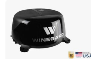 A black winegard antenna sitting on top of a table.