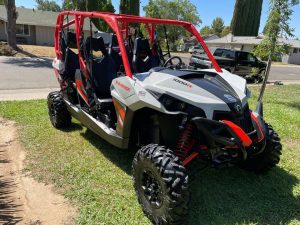 The 2017 Maverick Can-Am 4 person is parked in the yard.