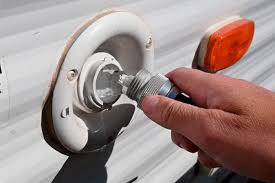 A person is putting a Add Fresh Water Tank Fill $25 Flat Fee plug into a white rv.