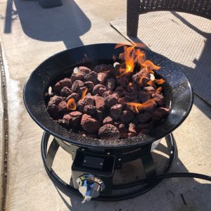 A Add Gas Fire Pit on a patio with flames on it.