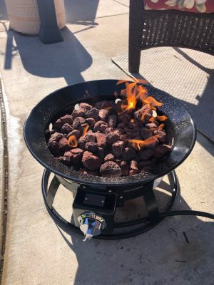 A Add Gas Fire Pit on a patio with flames on it.