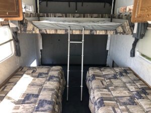 A couple of beds in the back of an rv.