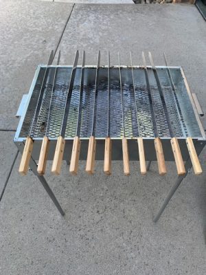 A Add Gas Fire Pit with several wooden sticks on it.