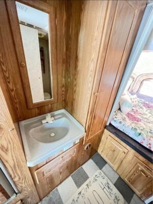 A bathroom with wood paneling and a sink.