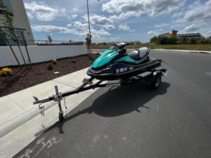 A jet ski is parked on the side of the road.