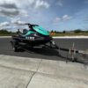 A jet ski is parked on the side of the road.