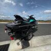 A black jet ski on the side of a road.