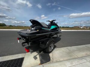 A black jet ski on the side of a road.