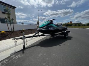 A jet ski is parked on the side of the road.