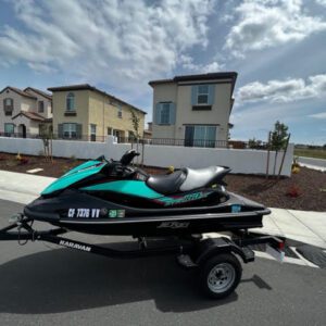 A jet ski is parked on the street near some houses.