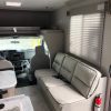 The interior of a 2021 Coachmen Freelander 30' Class C with a couch and a sink.