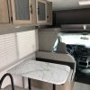 The interior of a 2021 Coachmen Freelander 30' Class C with a table and chairs.