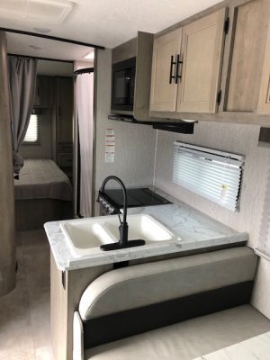 The interior of a 2021 Coachmen Freelander 30' Class C with a kitchen and sink.