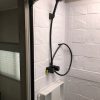 A shower in a 2021 Coachmen Freelander 30' Class C with a black shower head.