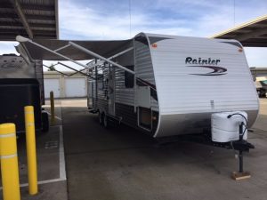 A 2011 Rainier Dutchman Bunk House 28' travel trailer parked in a parking lot.