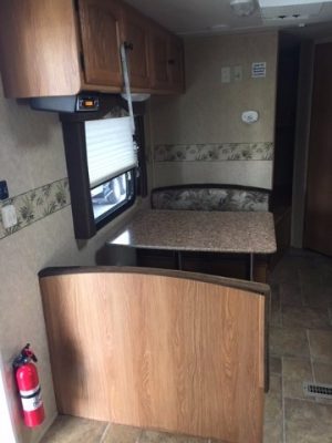 A small 2011 Rainier Dutchman Bunk House 28' with a kitchen and dining area.