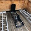 A wooden floor with two metal ramps and one ramp is open.