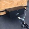 A bicycle is attached to the side of a trailer.
