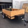 A trailer with wooden sides and black metal frame.