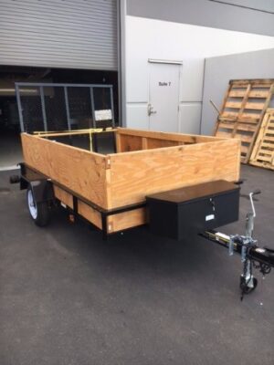 A trailer with wooden sides and black metal frame.