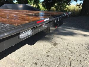 A flatbed trailer with wood on the back of it.