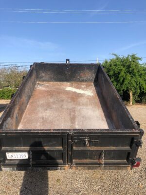 A black dump truck with the back open.