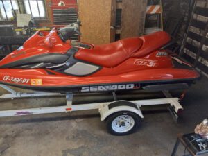 A red jet ski is parked on the trailer.