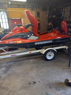 A red jet ski is parked in the garage.