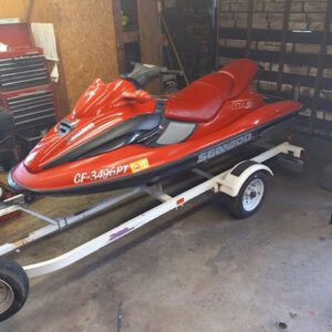 A red jet ski is parked on the trailer.