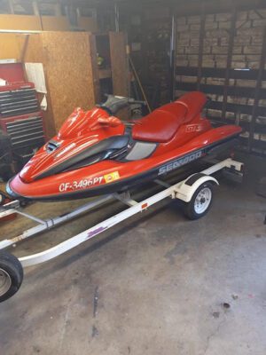 A red jet ski is parked on the trailer.