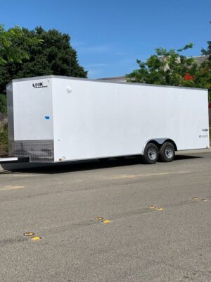 A white trailer parked on the side of a road.