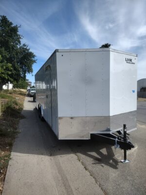 A white trailer parked on the side of a road.