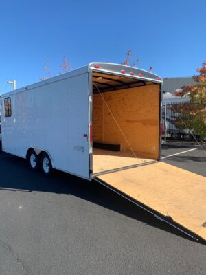 A white trailer with a wooden floor and a ramp.