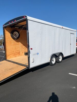 A white trailer with a wooden floor and open door.