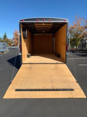A large trailer with a wooden floor and no wheels.