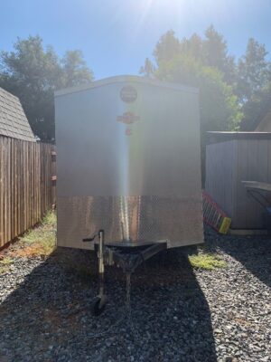 A trailer that is parked on the gravel.