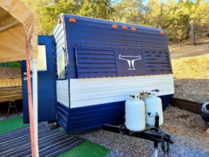 A blue and white trailer with two propane tanks.