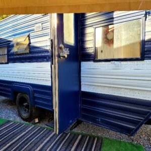 A blue and white trailer with a door open.